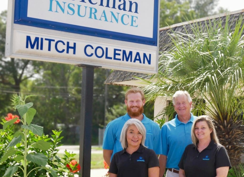 Read Our Reviews - Coleman Insurance Team Standing Together Beneath Agency Sign Outdoors
